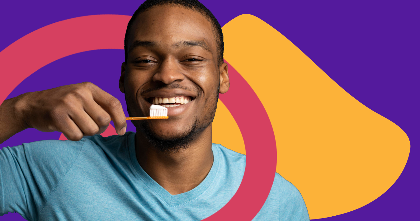 Homem negro sorrindo e segurando uma escova de dente com creme dental